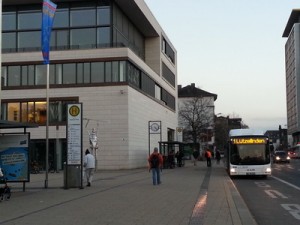 Die Stadtbuslinie 1 an der Haltestelle Berliner Platz in Gießen, direkt vor dem Rathaus mit der Glasfront des Stadtverordnetensitzungssaals im Vordergrund. Die Entscheidugnsträger blicken also auf den ÖPNV herab. Der Berliner Platz ist einer der zentralen Umsteigepunkte in Gießen.